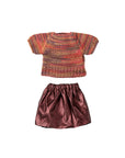 The Maileg "Skirt and knitted blouse, Mum mouse" set features a multicolored short-sleeve knit top and a shiny pink skirt, designed as charming mouse clothes and displayed on a white background.