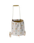 The Maileg Trolley by Maileg is a small toy shopping cart with a cream handle, frame, white wheels, and a linen basket featuring multicolored polka dots. Its easy-to-wash material ensures simple cleanup after playtime.