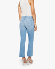 A woman wears Mother’s The Outsider Flood Fray light blue stretch denim bootcut jeans with raw hems, a white sleeveless top, and silver high-heeled sandals, shown from the back against a plain white background.