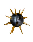 The Import Collection's Punk Candleholder features a dark metallic sphere with gold spikes, resembling a spiked mace. This edgy piece adds bold industrial style to any space and is shown against a white background.