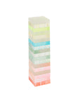 The Ombre Lucite Sherbert Jumbling Tower Stacking Game by Faire features translucent pastel blocks in green, yellow, blue, pink, and orange, stacked Jenga-style against a white background.