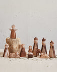 Minimalist nativity set featuring the holy family, an angel, wise men, and animals with a natural wood finish.