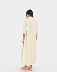 Xirena Boden long striped dress with rolled sleeves, styled with brown sandals for a relaxed, casual look.
