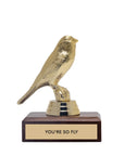 The JE Trophy by Faire features a golden bird on a wooden base with a plaque that says "YOU'RE SO FLY," making it an ideal gift for adults in Winston Salem, North Carolina.