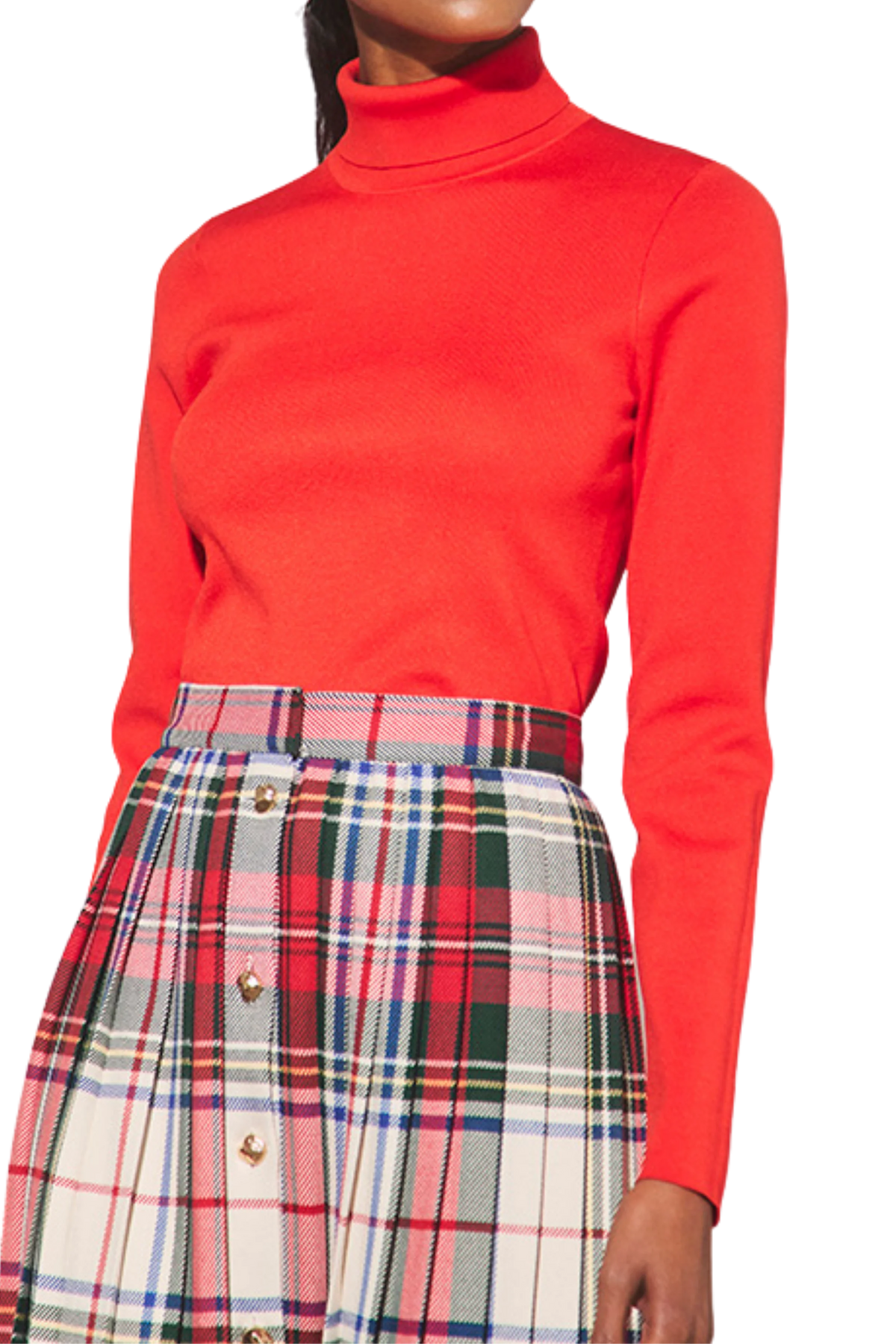 Red Hunter Bell NYC Roen turtleneck paired with a red, green, and cream plaid pleated skirt with gold buttons.