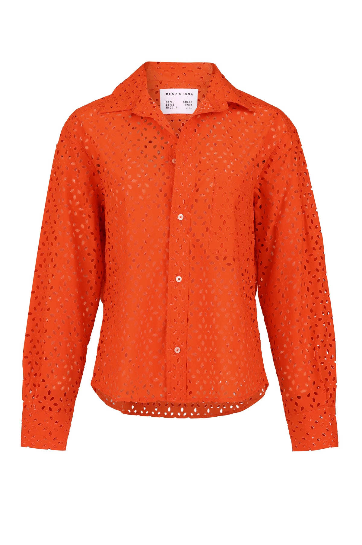 The Daily Shirt by Cissa is a bright orange long-sleeve crop shirt in airy paper cotton eyelet lace, with a collar, chest pocket, and all-over cut-out floral pattern—perfect for standing out every day.