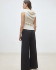 Sleeveless cream top and black wide-leg pants by SUNCOO Jet in soft organic cotton, shown from the back.