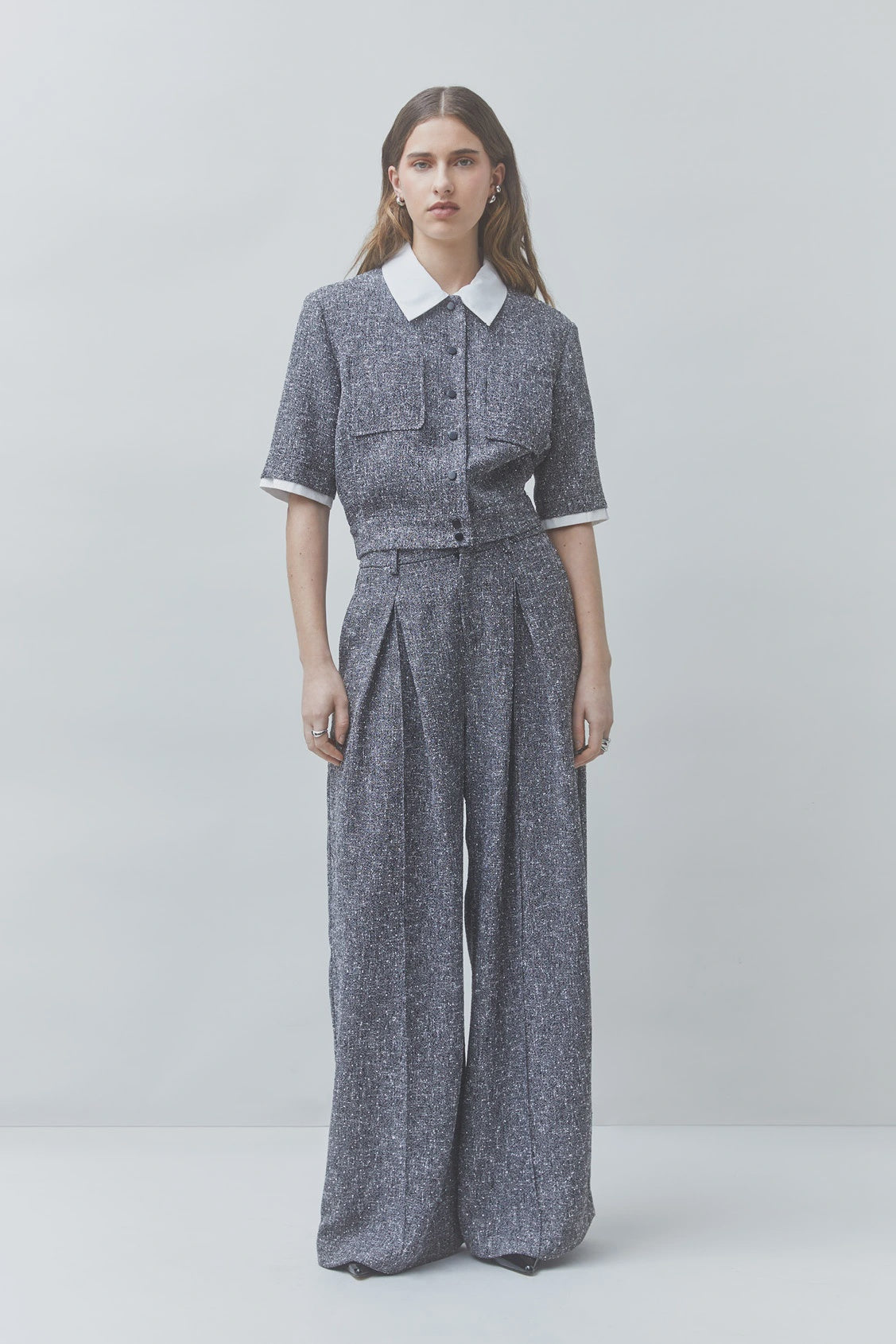 Gray wide-leg pantsuit and white shirtdress by SUNCOO in recycled polyester, styled on a plain neutral backdrop.
