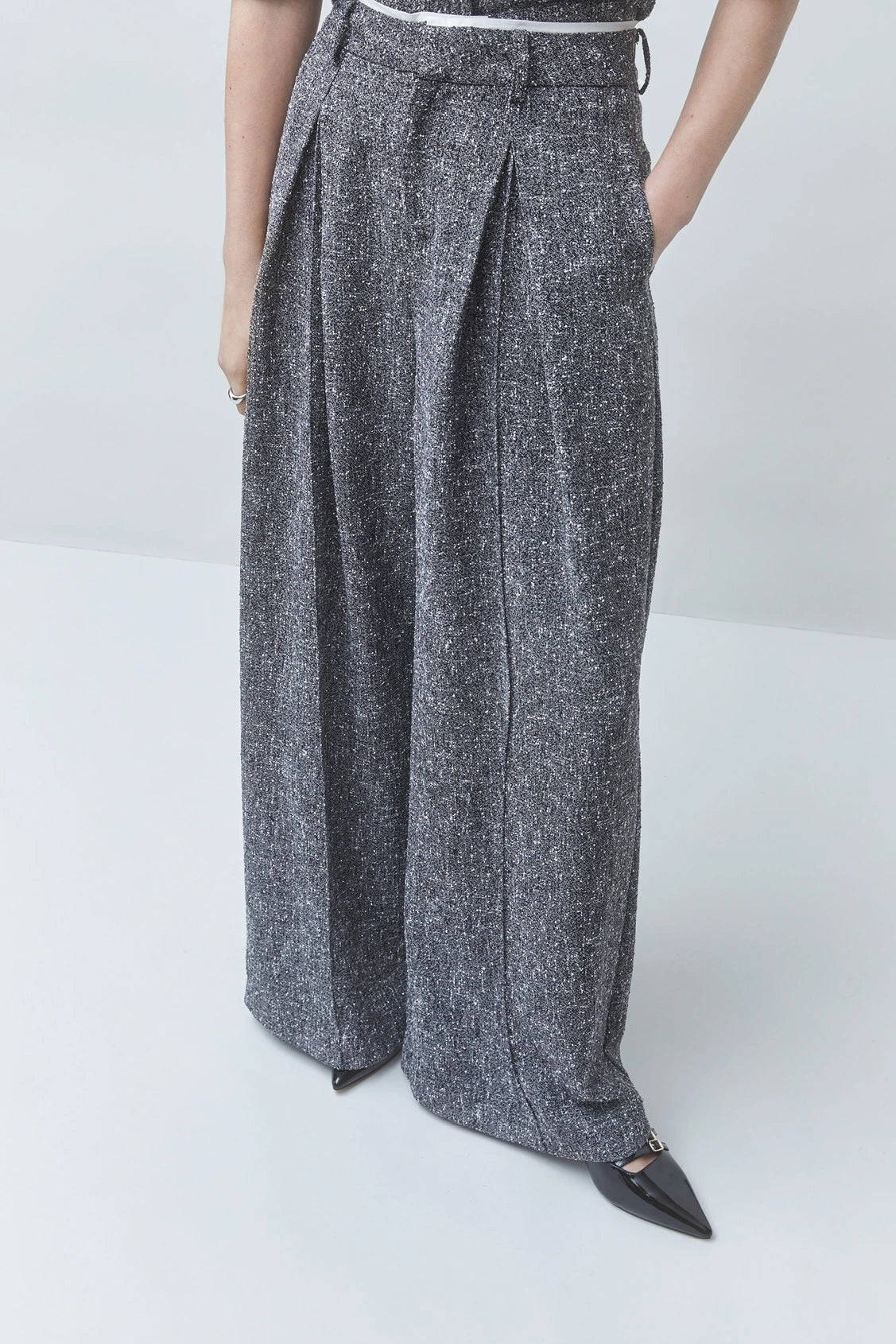 SUNCOO Jerk high-waisted wide-leg recycled polyester pants in black, styled with pointed-toe shoes.