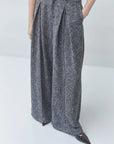 SUNCOO Jerk high-waisted wide-leg recycled polyester pants in black, styled with pointed-toe shoes.