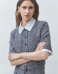 Gray SUNCOO Lino suit with short sleeves and white collar, modeled with a relaxed, modern style.