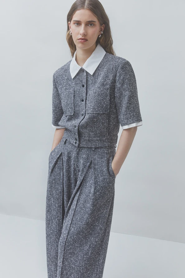 SUNCOO Lino gray textured pantsuit with white blouse, modern tailored look, neutral background.