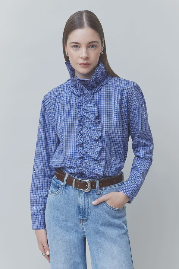 SUNCOO Lyes checked Victorian-style shirt in neutral tones, tucked into jeans with a brown belt.