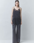 SUNCOO Lune Shirt in white with wide-leg gray trousers, relaxed modern style against a pale backdrop.