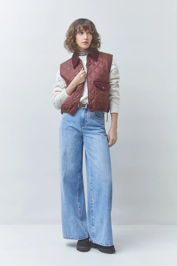 Maroon sleeveless quilted jacket by SUNCOO with cream sweater and wide-leg jeans, casual modern style.