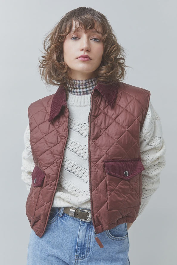 SUNCOO Djess maroon quilted sleeveless jacket with velvet collar, styled over a white sweater and blue jeans.