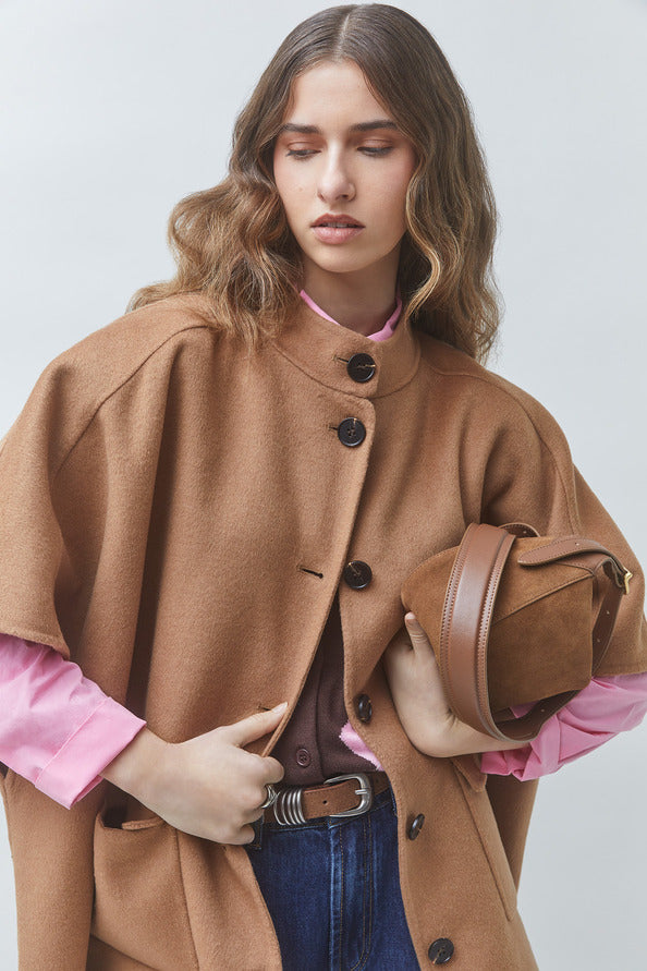 SUNCOO Ezra front-buttoned coat in soft pink, styled with a brown bag and wavy hair for a chic look.