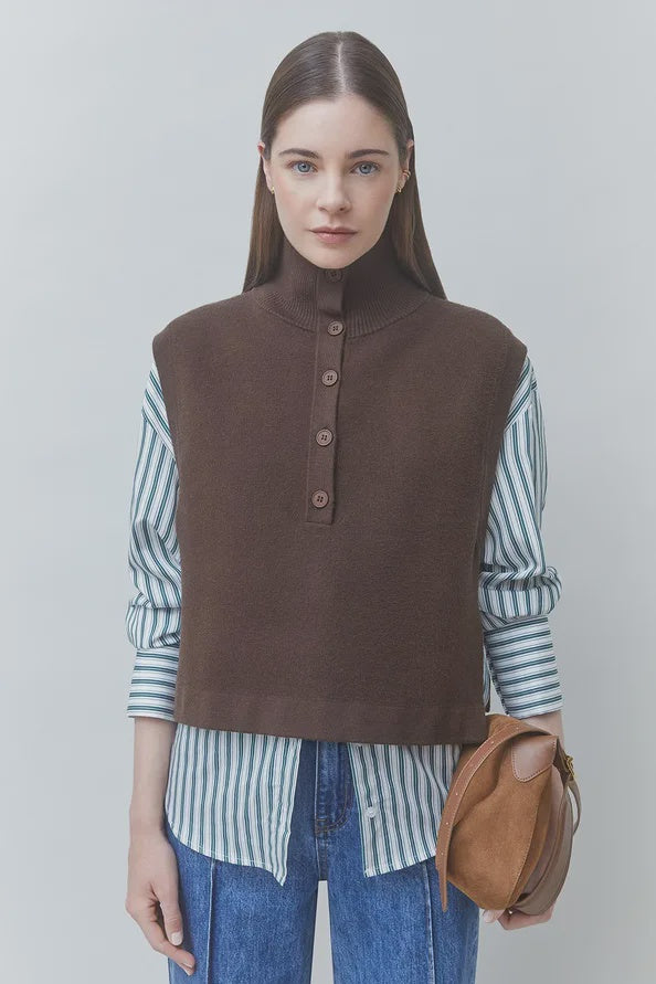 SUNCOO Pacomi striped button-up shirt and brown jumper styled with jeans and bag, neutral modern backdrop.