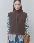 SUNCOO Pacomi striped button-up shirt and brown jumper styled with jeans and bag, neutral modern backdrop.