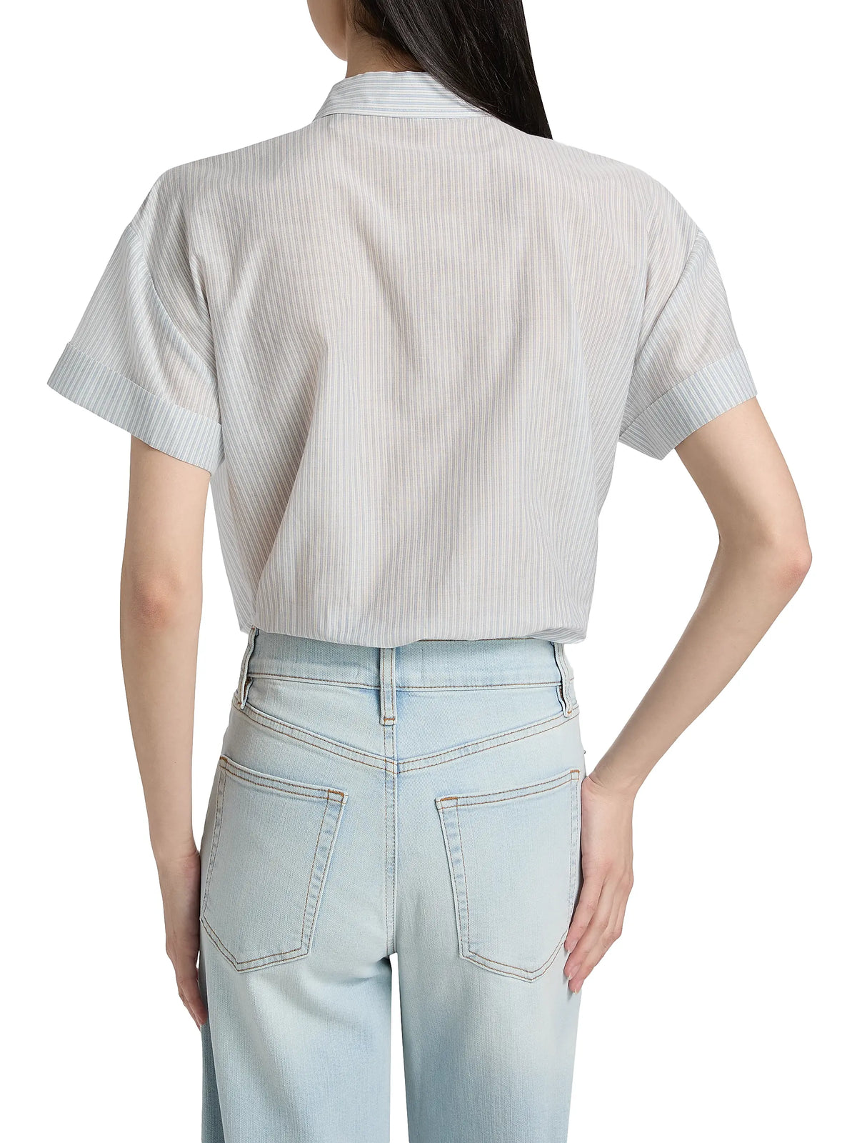 Someone is seen from behind wearing the light blue FRAME The Boardwalk Shirt with one hand on their hip, paired with light-wash jeans.
