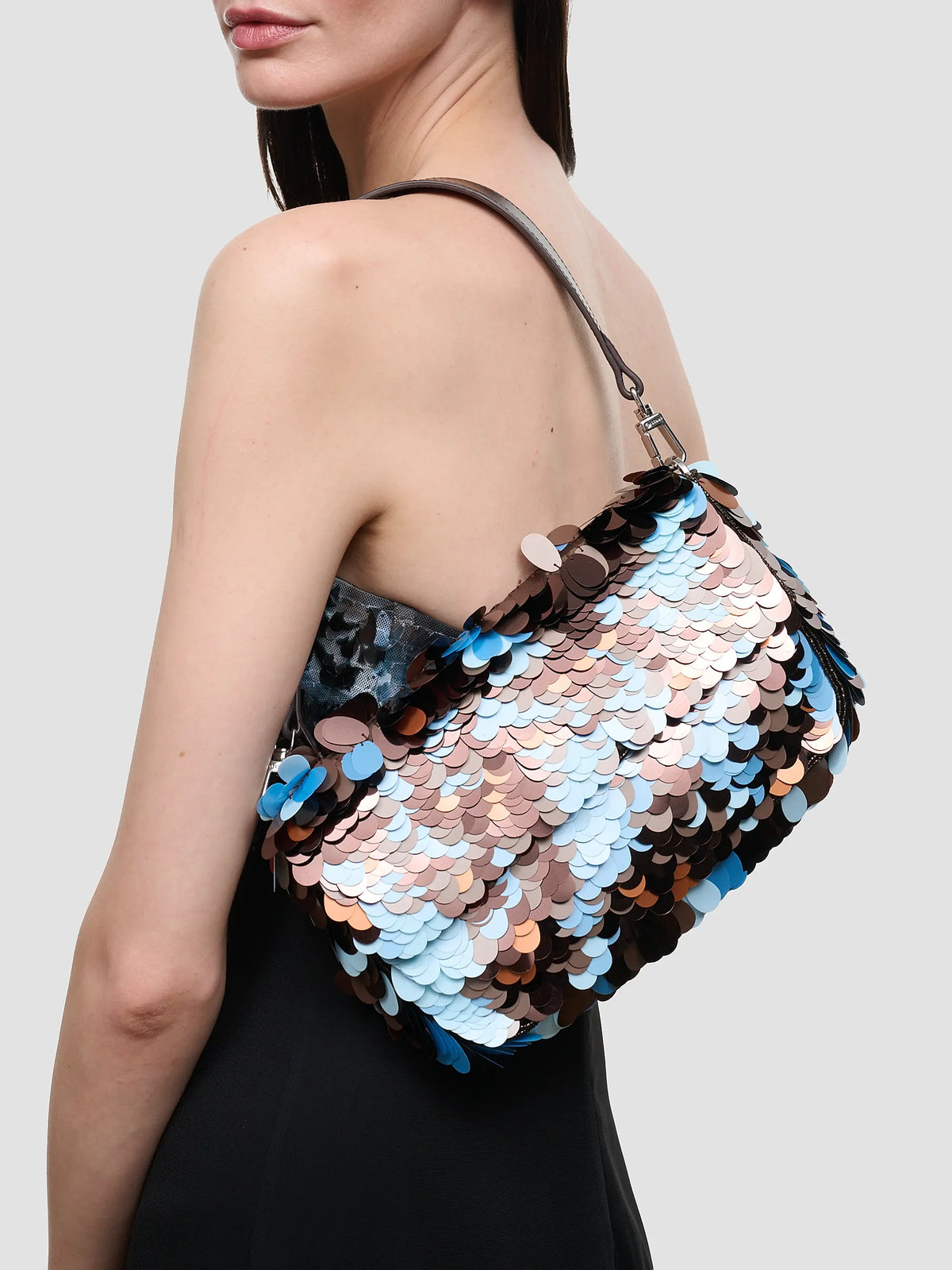 Staud Timmy Convertible Shoulder Bag with embellished paillettes and leather strap, carried by woman with dark hair.