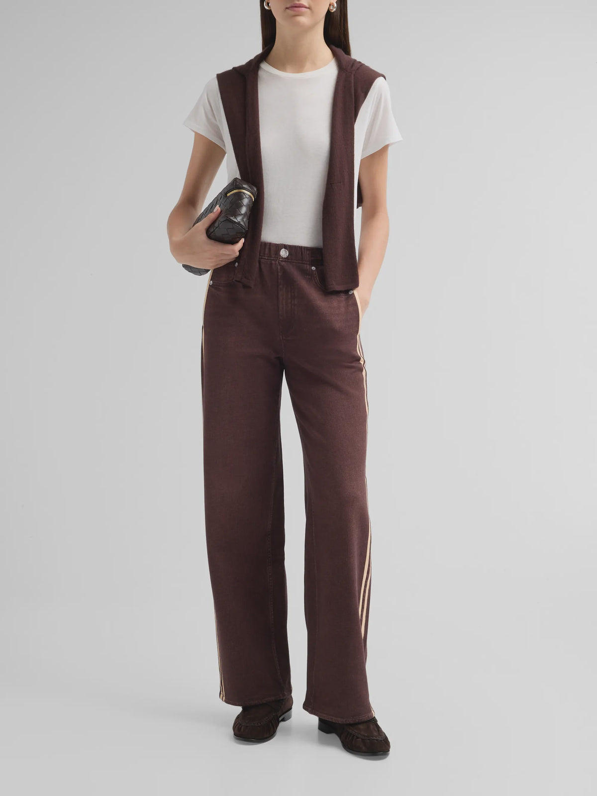 Rb Miramar terry track pull-on jeans, white t-shirt, and brown sweater draped over shoulders on a model.