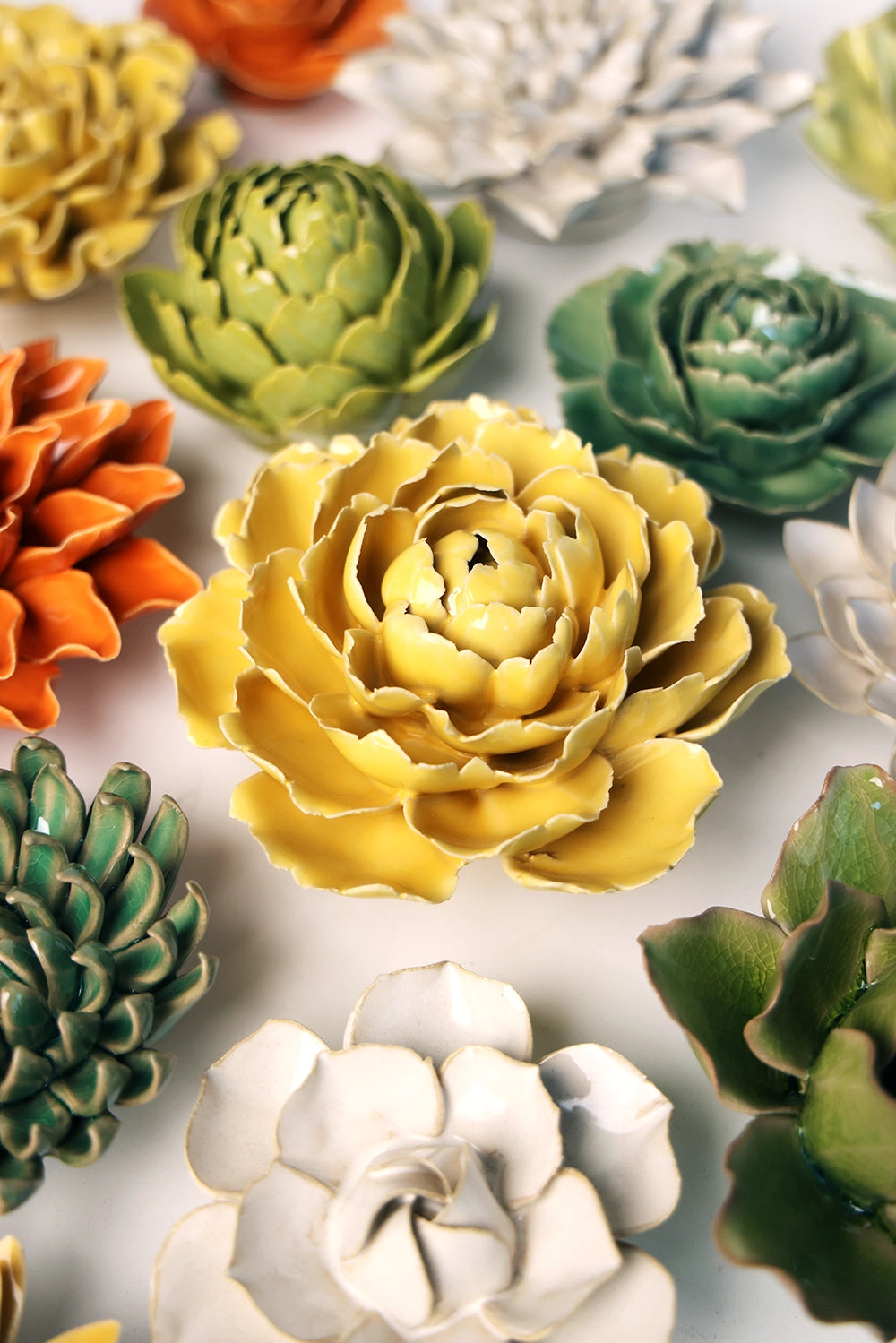 The Buttercup Yellow Peony by Faire features intricately crafted ceramic petals in a vibrant yellow hue, mimicking real succulents to create striking handmade home decor.