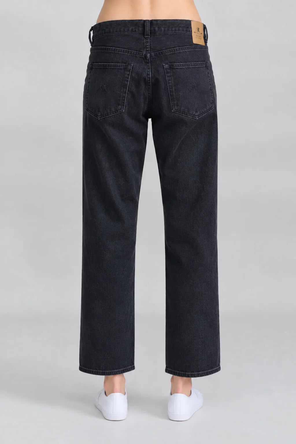 Black Denimist LUCY BF straight-leg jeans styled with white shoes, shown against a light gray background.