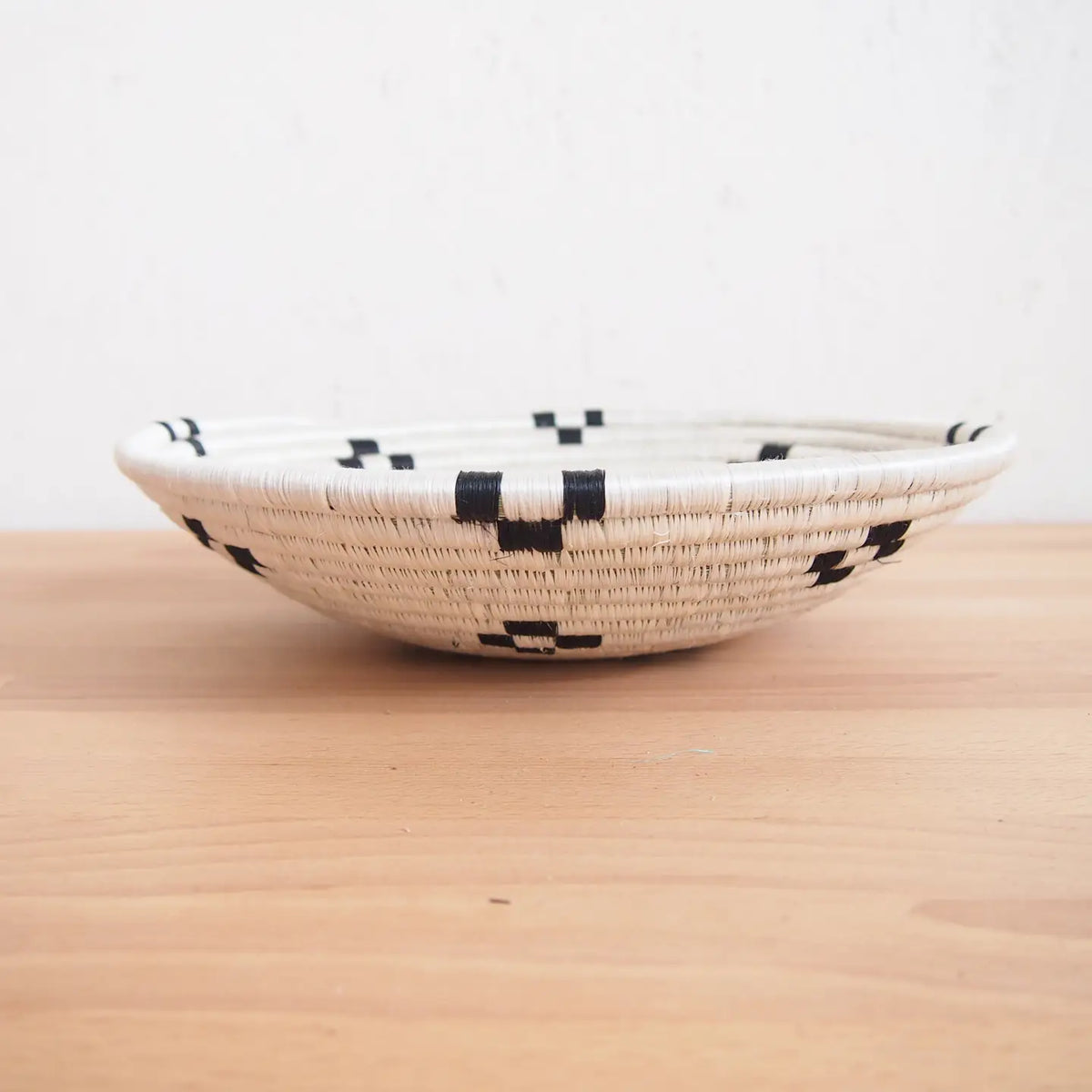 Small bowl with black geometric pattern on light wood surface, Bungalow Furniture & Accessories, Faire Maraba collection.