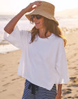 Frank & Eileen Presley Oversized Tee styled with striped pants and sunhat on a sandy beach at sunset.