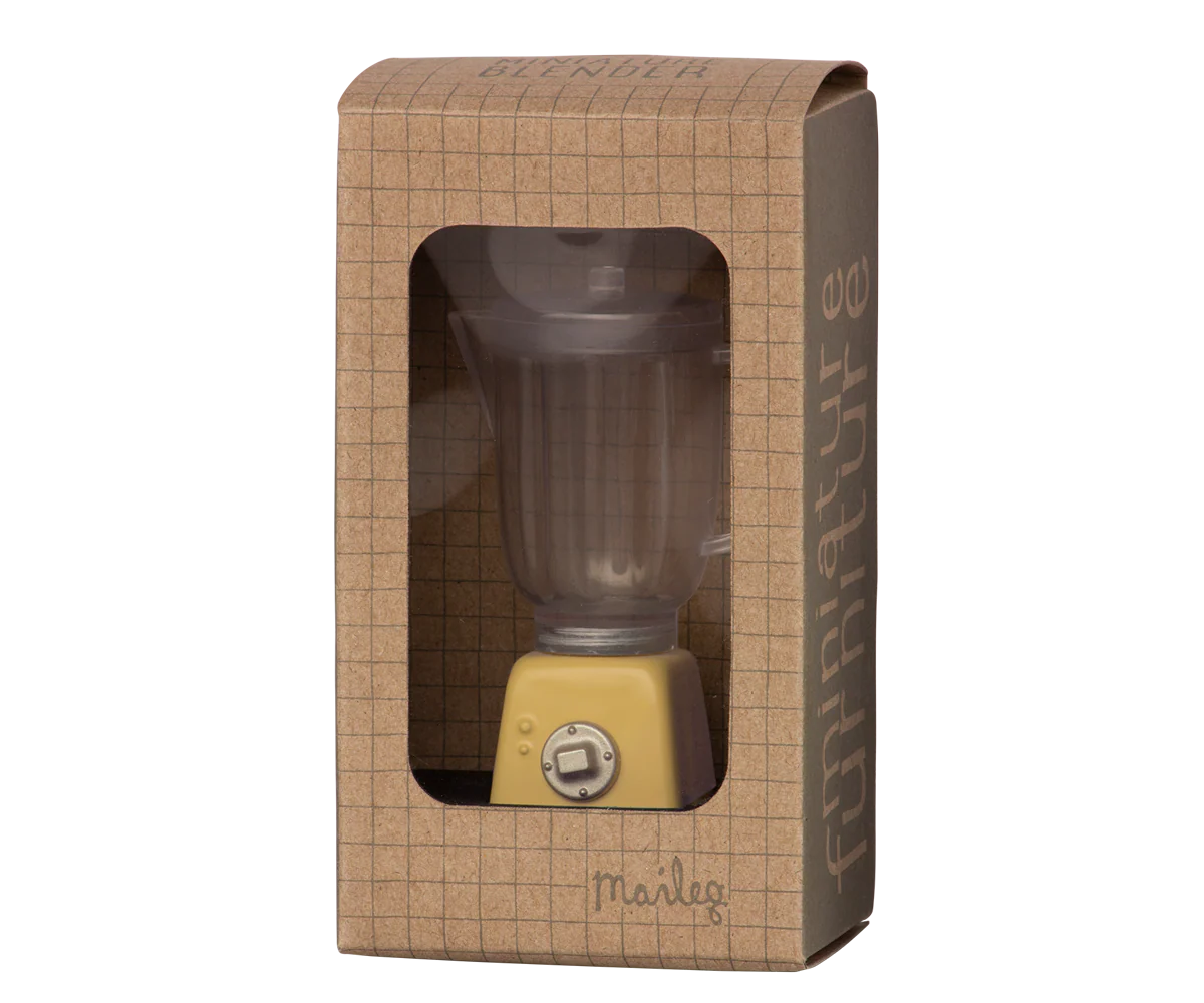 The Maileg Blender, a miniature toy with a yellow base and clear container, comes in a brown grid-patterned box labeled "furniture" by Maileg—ideal for bunny kitchens or rabbit toy setups.
