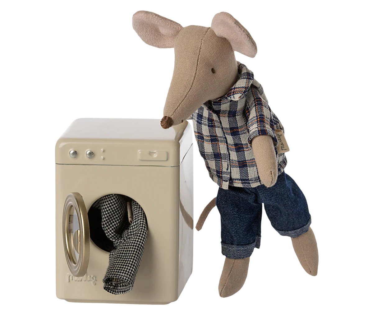 A Maileg mouse doll, dressed in a plaid shirt and jeans, stands next to the Maileg Washing Machine with checkered laundry partially inside.