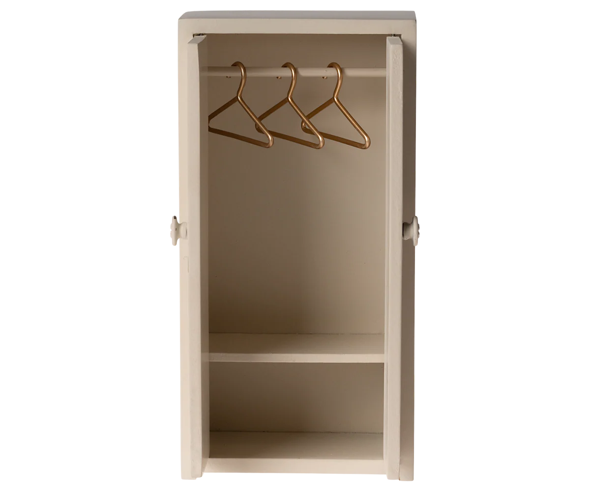 Small beige Maileg wardrobe with shelves and gold hangers, ideal for dollhouse collections at Bungalow Furniture.