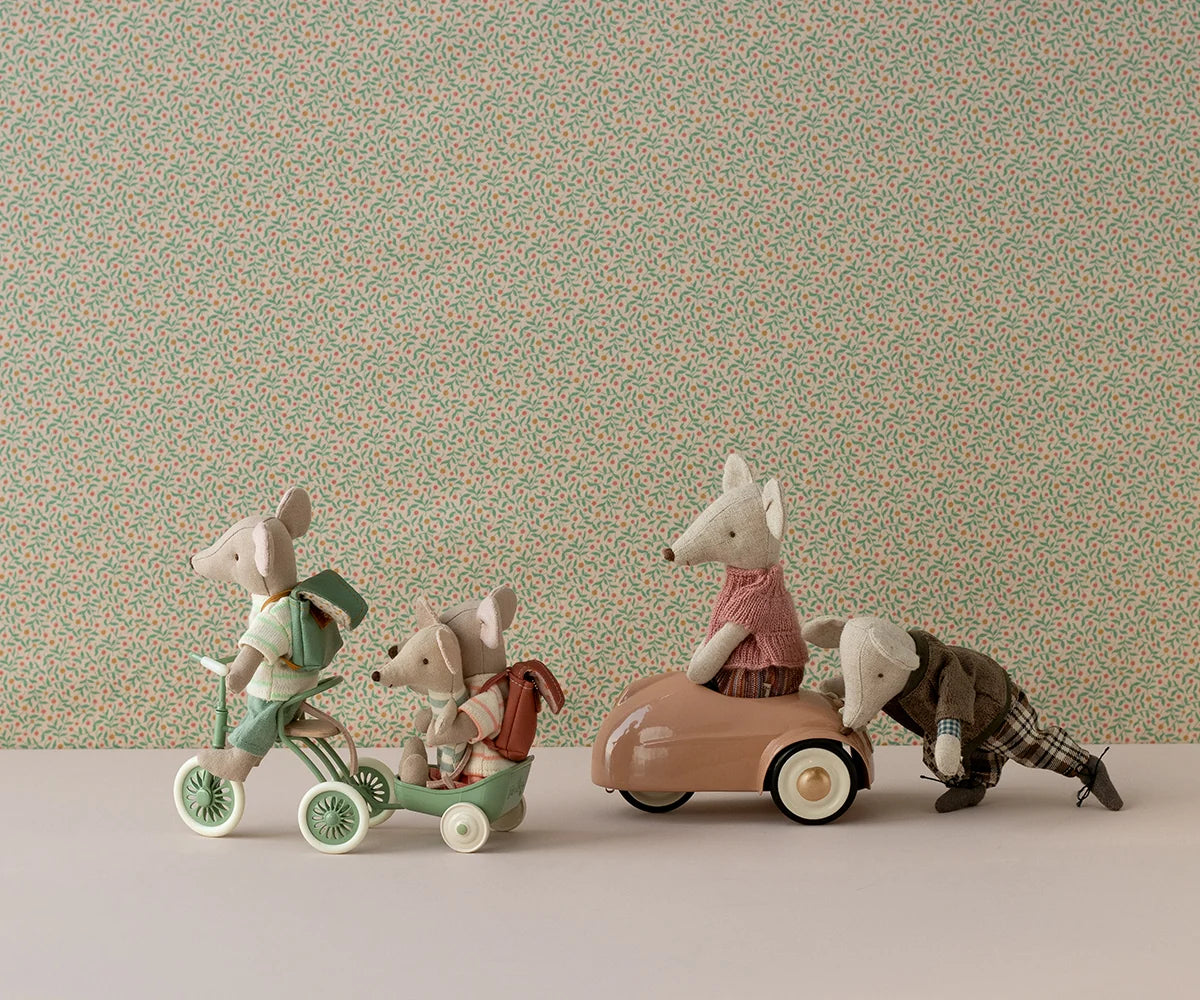 Toy mice with magnetic paws ride tricycles by a floral backdrop, Maileg Abri a Tricycle collection.