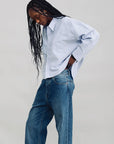 Denimist BAILEY Cropped Stripe Oxford shirt and loose jeans, styled on model with long braids against a plain backdrop.