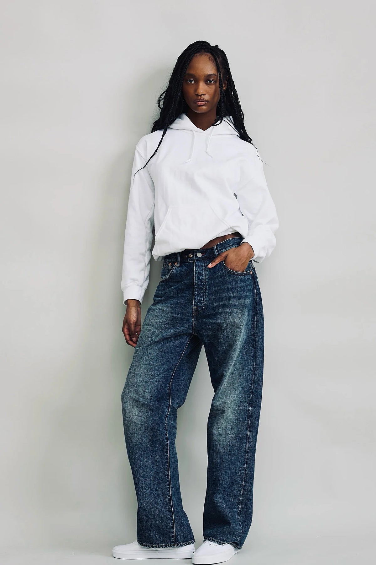 Denimist ALLFIT JEAN in classic denim, styled with a white hoodie, shown against a minimal background.