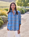 Frank & Eileen Eileen 26 shirt in white styled with white pants on a sunny garden path surrounded by lush greenery.