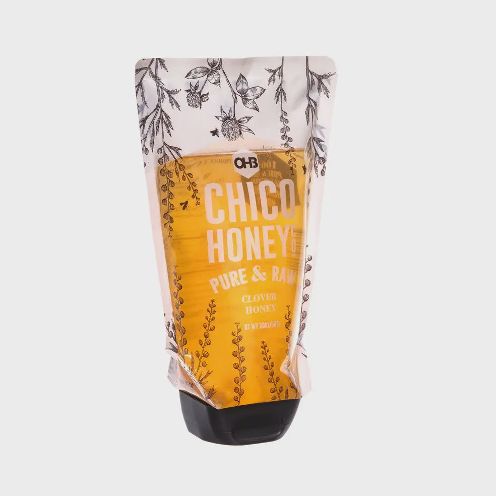Experience the delightful taste of Faire's Olivarez Chico Honey in a convenient 26-ounce squeeze pouch. The mostly yellow packaging features charming sketches of flowers and plants, capturing the essence of its clover varietal goodness.