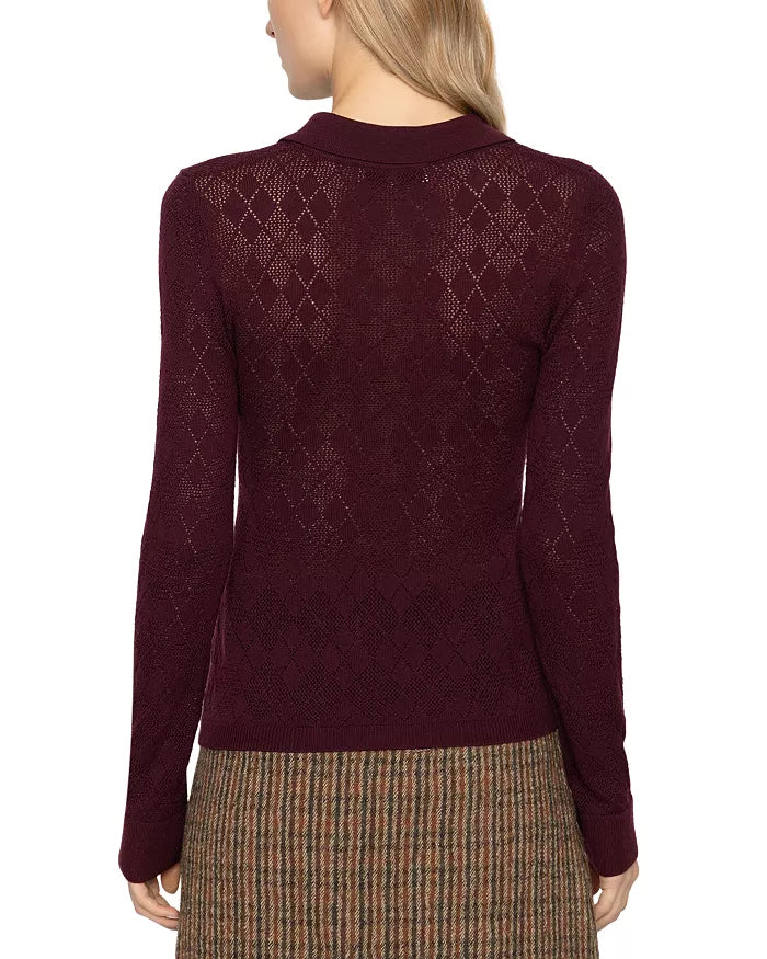 Brown plaid skirt and argyle polo sweater by Sea New York, seen from the back in a casual setting.