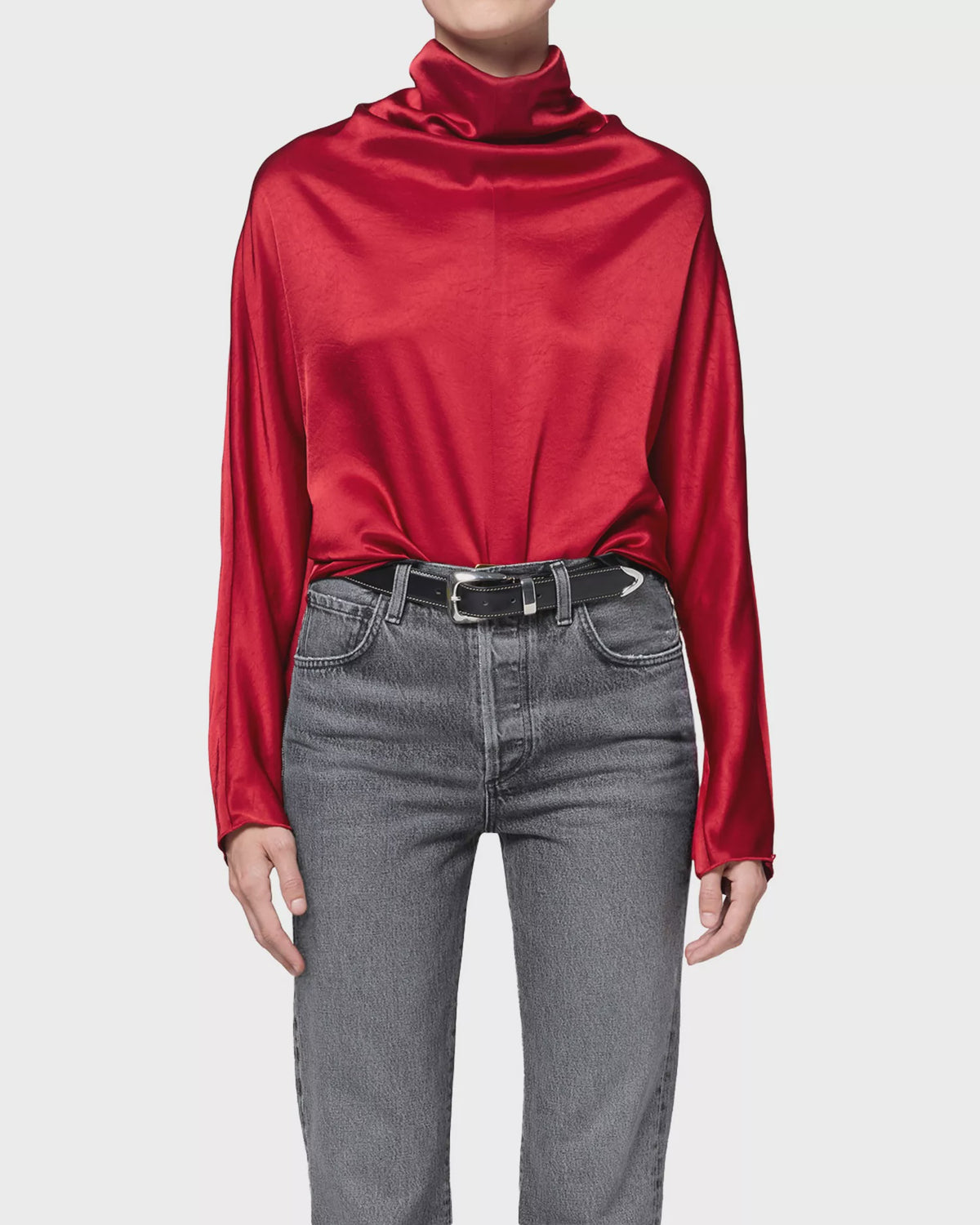Ilaria Draped Top in long-sleeve hammered satin, styled with grey jeans and a black leather belt.