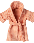 Coral pink textured bathrobe with tie belt by Maileg on a white background, cozy kids clothing.