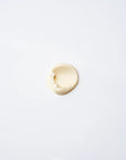 A small dollop of Faire Tallow Sunscreen SPF 50 is spread in an oval shape on a smooth, white surface.
