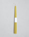 A pair of 18" Taper Candles by The Floral Society in yellow, crafted from premium materials, are joined at the wicks with a white label and displayed on a light gray background.