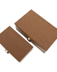 Harriett Box storage boxes in fabric with textured brown wood-grain lids and brass-toned knobs by Bungalow Furniture.