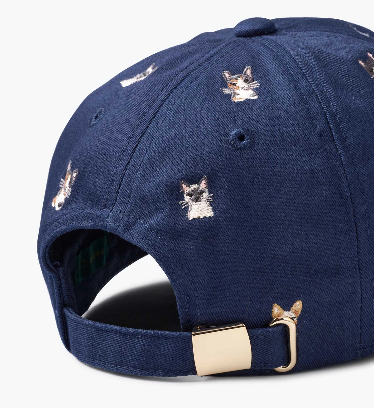 Navy baseball cap with embroidered cat faces and gold buckle, Faire Cool Cats collection at Bungalow Furniture.