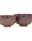 Two Linden Bowls by The Import Collection, featuring a matte gradient brown glaze, are displayed side by side. Each round bowl has a small pedestal base and differs in size, making them ideal decorative accents for your home.