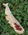 Mango wood whale-shaped dish with strawberries by Be Home, styled among fresh strawberry plants and leaves.