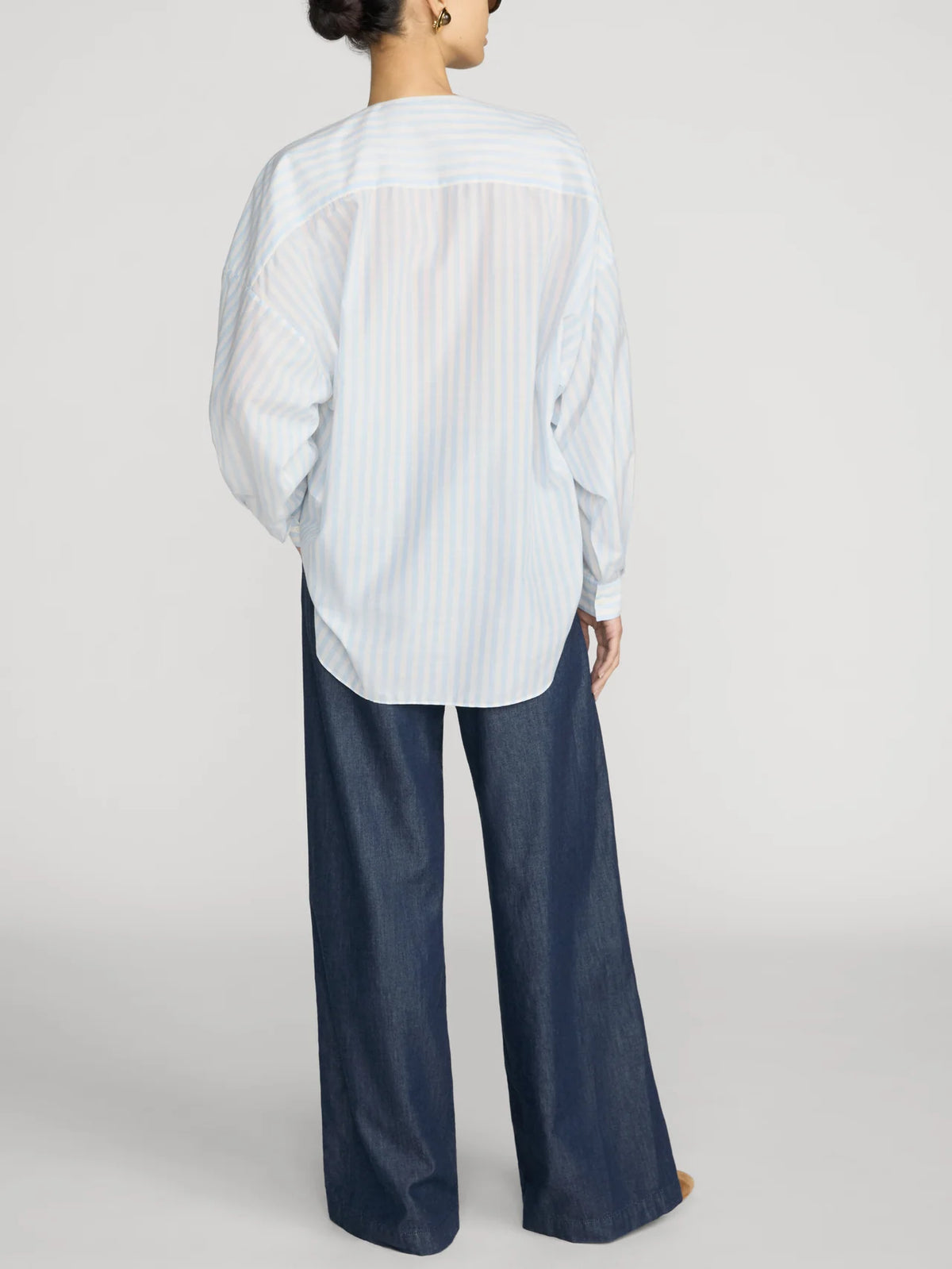 FRAME Offshore Pant in relaxed wide-leg fit, shown from the back with a loose blue striped shirt.