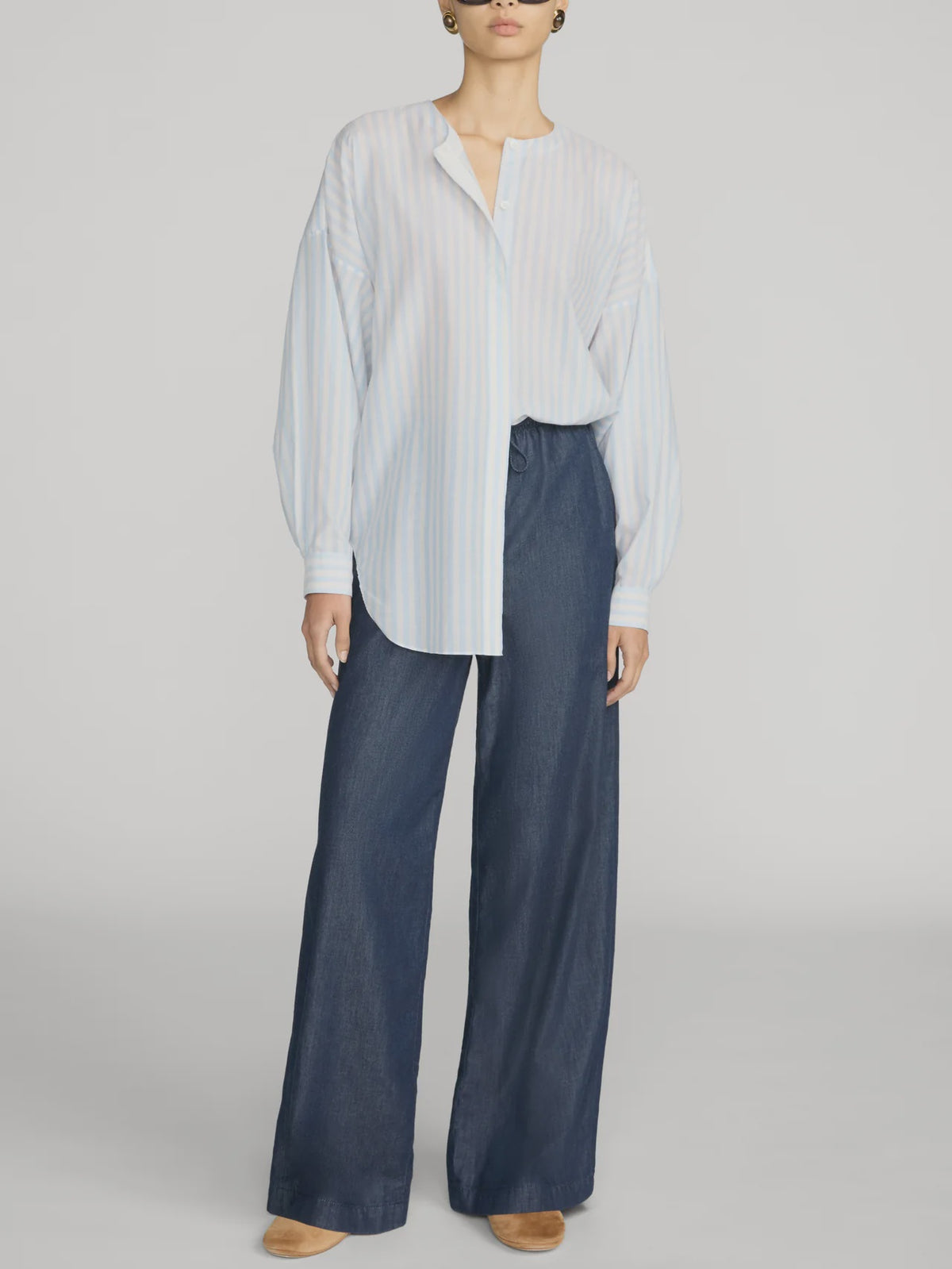 The Offshore Pant by FRAME in a relaxed fit with drawstring waist, styled with a white striped blouse and tan shoes.