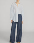 The Offshore Pant by FRAME in a relaxed fit with drawstring waist, styled with a white striped blouse and tan shoes.